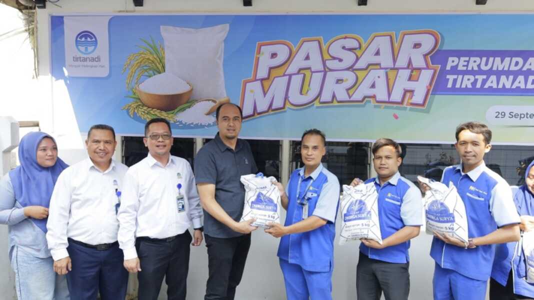 SERAHKAN: Direktur Utama Perumda Tirtanadi Adrian Surbakti menyerahkan secara simbolis bahan pokok berupa beras pada pelaksanaan pasar murah yang berlangsung di halaman parkir belakang Kantor Pusat Perumda Tirtanadi.