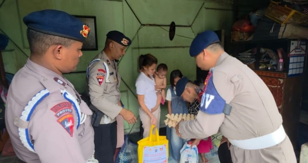 SEMBAKO: Provos Satbrimob Polda Sumut memberikan sembako kepada seorang warga yang tinggal di pinggiran rel kereta api, Jalan Ampera, Kelurahan Glugur Darat 1, Kecamatan Medan Timur, Rabu (30/9). Istimewa/Sumut Pos