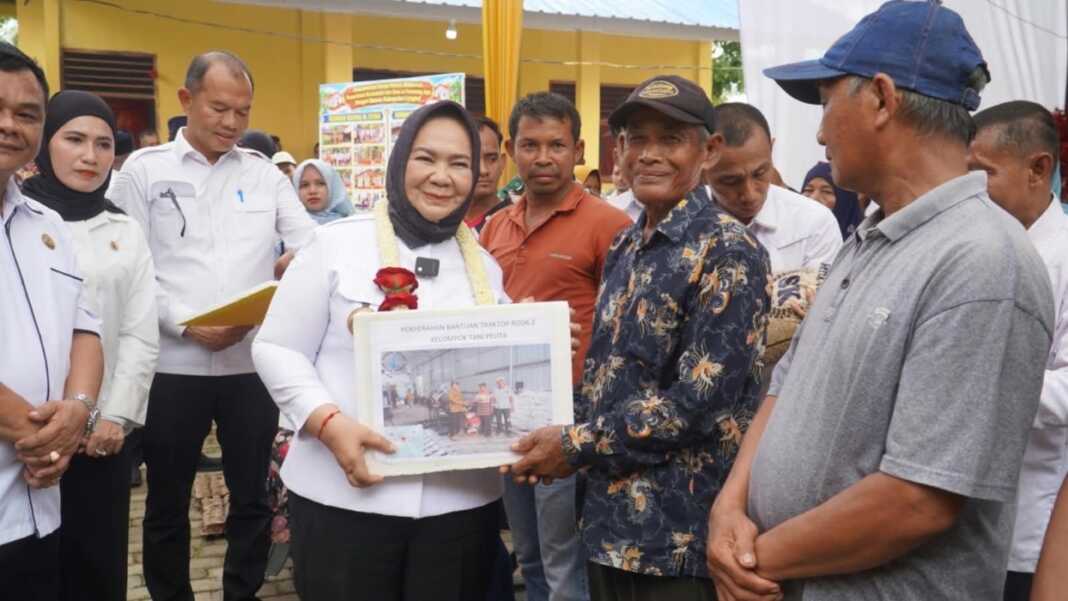 Plt Bupati Langkat Tiorita br Surbakti saat menyerahkan bantuan kepada masyarakat secara simbolis.