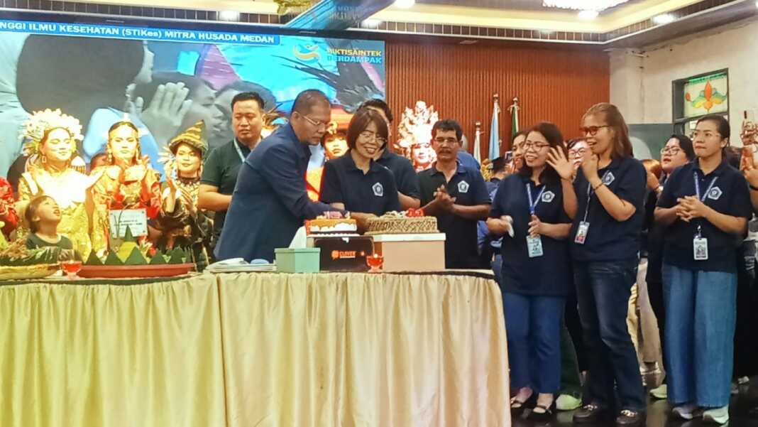 20 TAHUN: Dr. Imran Saputra Surbakti, M.M dan Dr. Siti Numawan Sinaga, M.Kes memotong kue ulang tahun dies natalis ke-20 STIKes Mitra Husada Medan. (Deddi Mulia Purba/Sumut Pos)