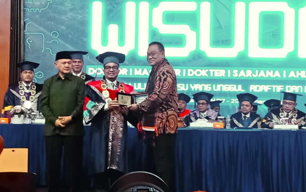 WISUDA UMSU: Mohammad Jumhur Hidayat (kanan) menerima cendera mata dari Prof. Dr. Akrim Lubis, M.Pd didampingi ketua PP Muhammadiyah, Selasa (27/10). (Deddi Mulia Purba/Sumut Pos)